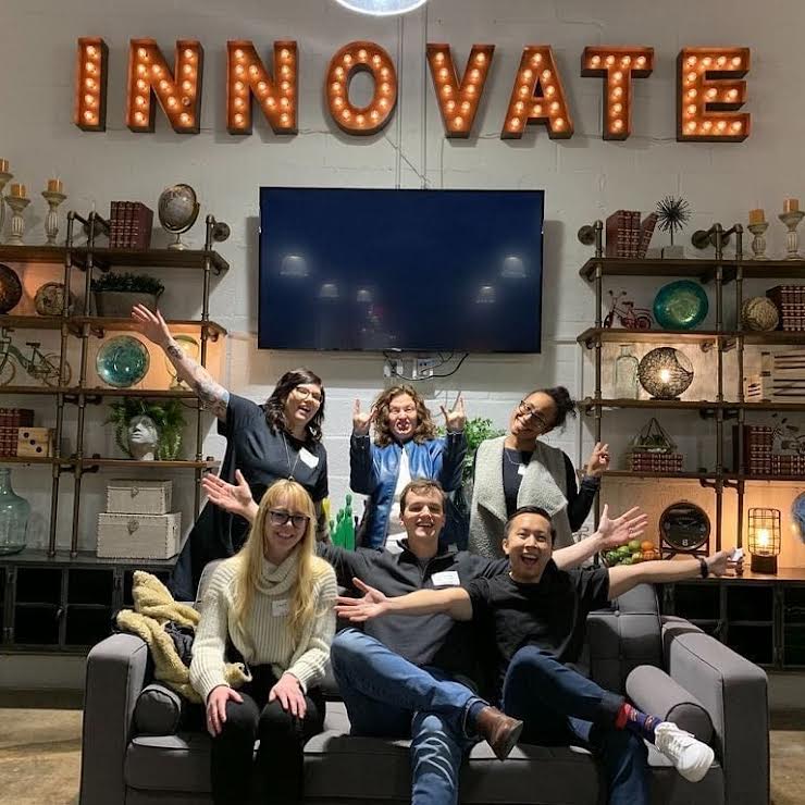 2021 PhillyCHI board posing in front of a sign reading "INNOVATE"